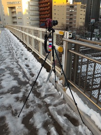 2016年1月18日の東京の大雪の日に、池袋のごみ焼却場がある陸橋でD5300で、雪景色をインバータル撮影している様子をASUSのZenfone2で撮影